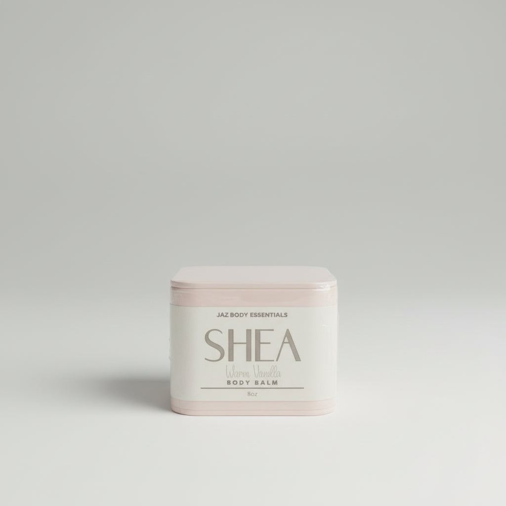 Jar of Shea body butter on a wooden surface with a blurred green background