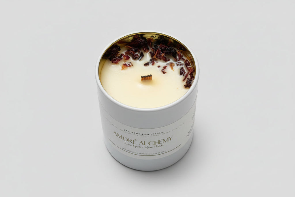 Candle in a container labeled 'Amöre Alchemy' on a textured surface