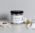 Jar of magnesium bath soaks with a bottle of 'Relax' oil on a marble surface.